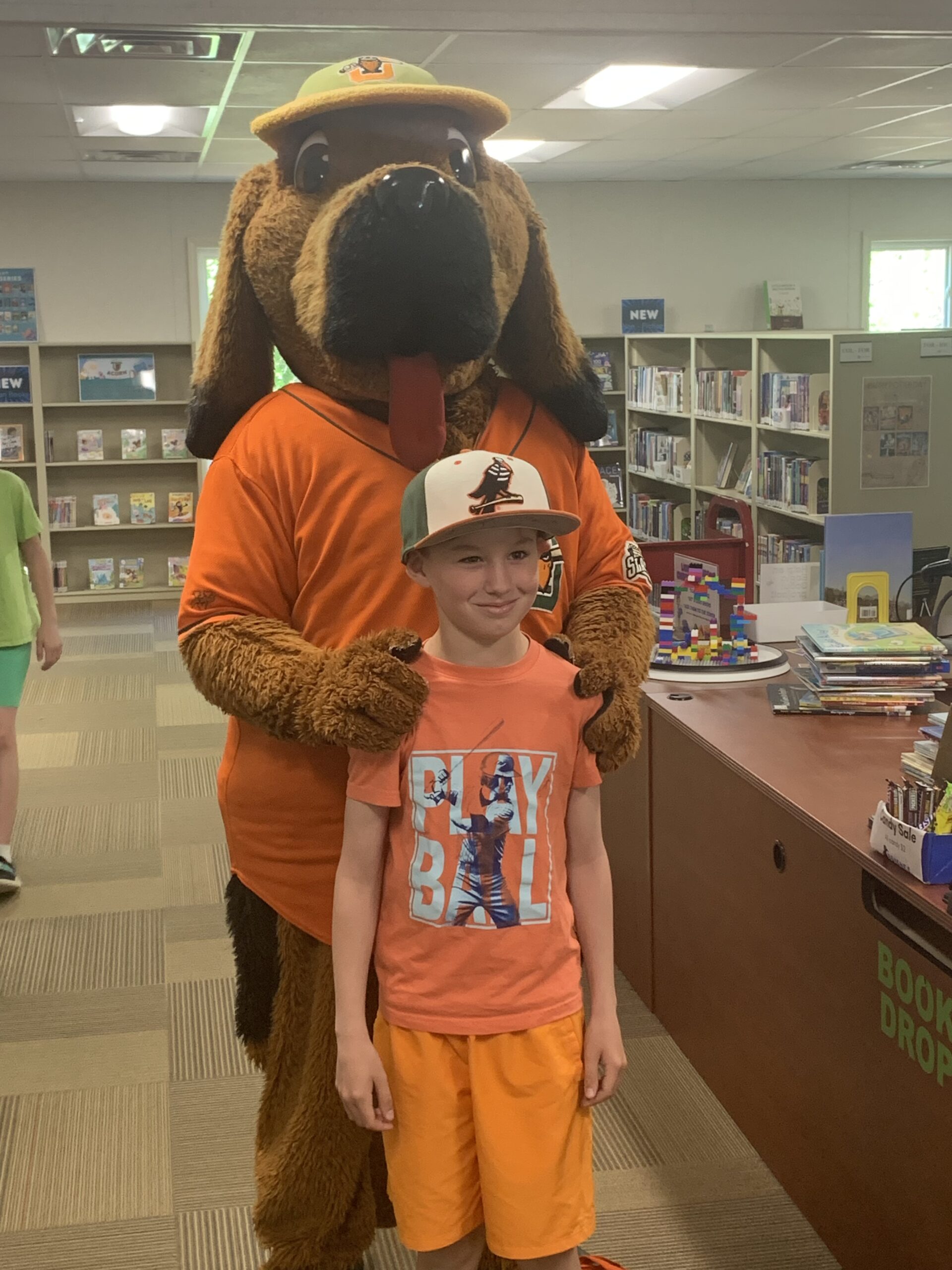 Image of a young patron and Spikes the Joliet Slammers mascot at a recent library event
