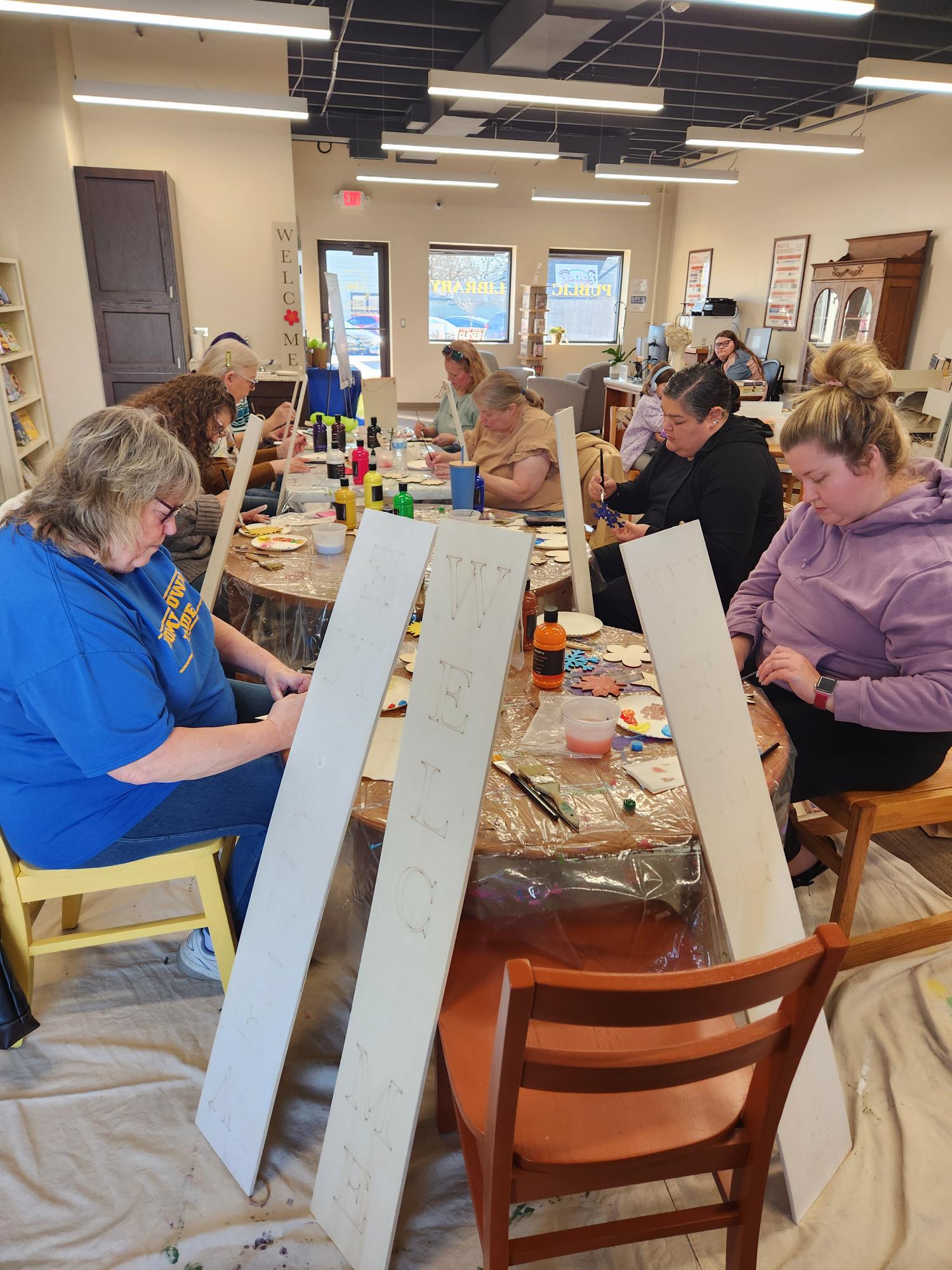 Image of patrons painting at the Seasonal Porch Board event at the Elwood Branch